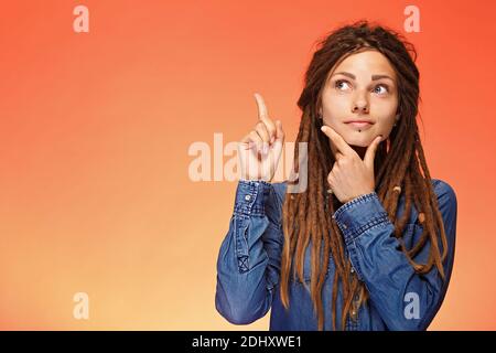 Portrait of pensive young woman who has good idea Stock Photo