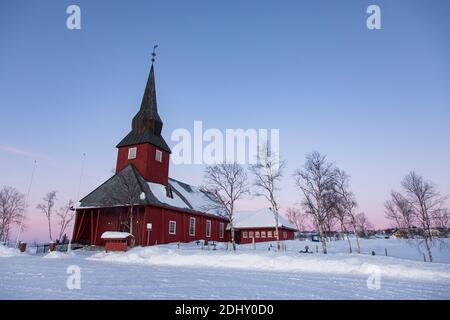 Lapland, Norway: Red church near a snowy cemetery in the norwegian countryside Stock Photo