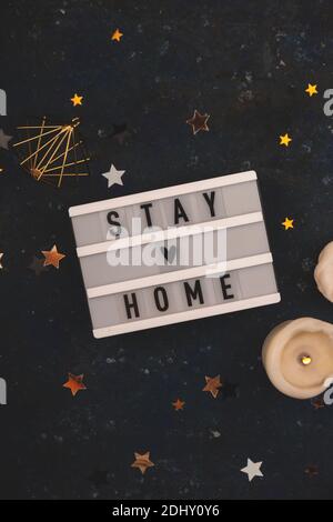 Stay Home written on lightbox among Christmas decorations Stock Photo