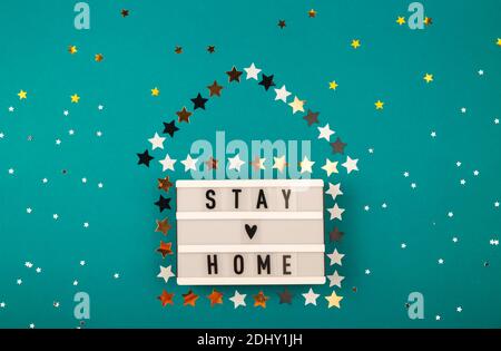 Stay Home written on lightbox among Christmas attributes Stock Photo