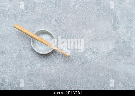 Bamboo toothbrush in holder on grey background. Zero waste concept Stock Photo