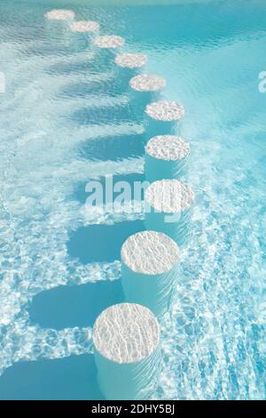 Round bar stools under water. Healthy lifestyle, adventure. Outdoor pool on a sunny summer day. Background. Clear turquoise water in the pool. Rest, t Stock Photo