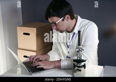 Virus researcher specialist. Medical healthcare scientist in lab researching vaccine antivirus medicine corona virus COVID-19 using computer laptop mi Stock Photo