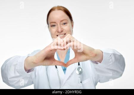 young smiling female doctor making heart sign with her hands Stock Photo