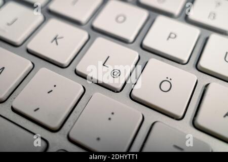 Close up and macro detail view at German alphabet on white buttons of modern aluminium computer's keyboard. Stock Photo