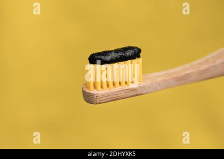 Eco friendly natural bamboo toothbrush with black charcoal whitening toothpaste Stock Photo