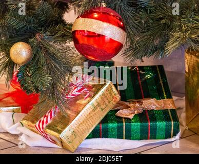 Decorative Santa Claus sleigh with colored gifts boxes under christmas tree. Stock Photo