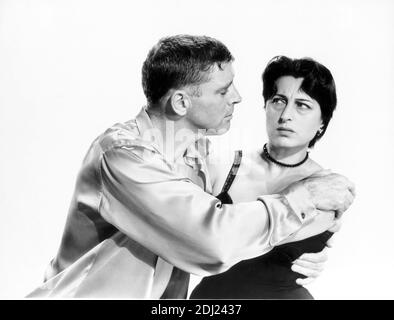 1955 , USA : The celebrated italian movie actress  ANNA  MAGNANI with BURT LANCASTER  in Hollywood Paramount Pictures Studio for the movie THE  ROSE TATTOO ( 1955 - La rosa tatuata ) by  Daniel Mann , from a play by Tennessee Williams  - MOVIE - FILM - CINEMA - attrice - portrait - ritratto  - sottoveste - camicia di raso - satin shirt - collana - necklace - neck-lace  - black pearl - pearls - perla - perle  ----  Archivio GBB Stock Photo