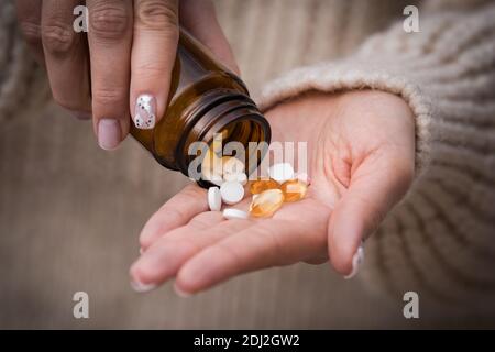 Close up on woman hands. Female taking vitamins, minerals and supplements. Jar with pills. Stock Photo