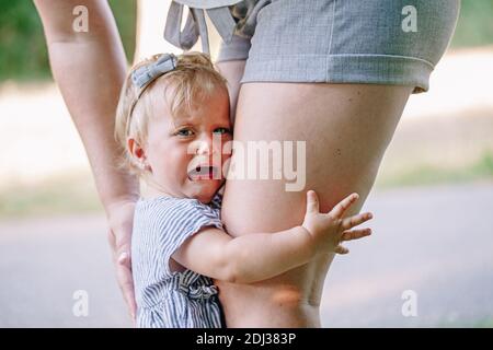 Kids toddlers tantrum. Crying baby girl in park outdoor. Mother pacifying sad upset crying toddler girl. Bonding relationship of mom parent and child Stock Photo