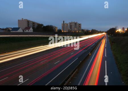 Light trail of cars on a highway during the morning. Spun vehicles on the road as seen from a bridge. Lightpainting scene. Stock Photo