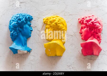 Three statues of david with colors of red and blue and yellow on the wall in Dafen Oil Painting village, Shenzhen, China. Stock Photo