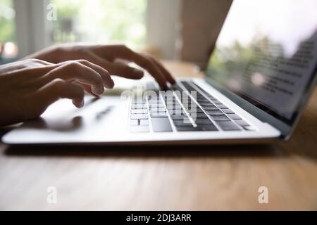 Close up female hands typing on laptop keyboard, working online Stock Photo