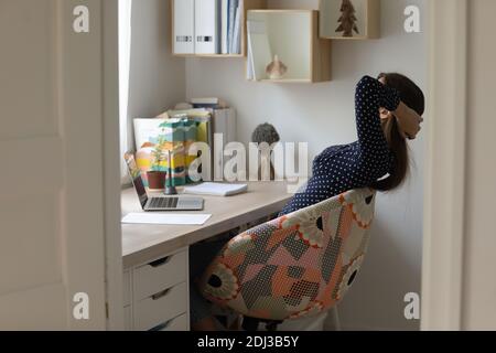 Side view relaxed young woman stretching in comfortable office chair Stock Photo