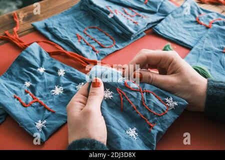Fabric bags for Christmas gifts and handmade numbers with decorations on the table. Hand made Advent calendar for Christmas Stock Photo