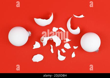 Top view of shattered Christmas tree glass bauble broken into many pieces on red background Stock Photo