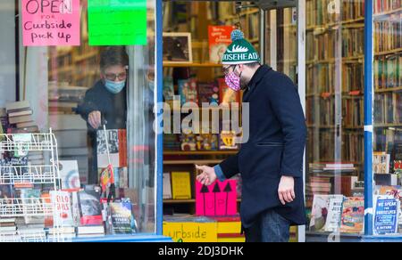 Toronto, Canada. 12th Dec, 2020. A man wearing a face mask waits outside a bookstore as a shop assistant picks up a book for him in Toronto, Canada, on Dec. 12, 2020. Canada has confirmed a total of 453,257 COVID-19 cases and 13,337 deaths as of Saturday afternoon, according to the Canadian television network CTV. Credit: Zou Zheng/Xinhua/Alamy Live News Stock Photo
