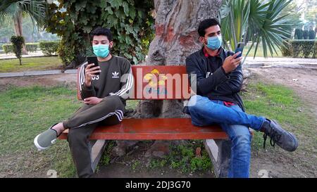 Friends sitting on bench Wearing Face Mask Stock Photo