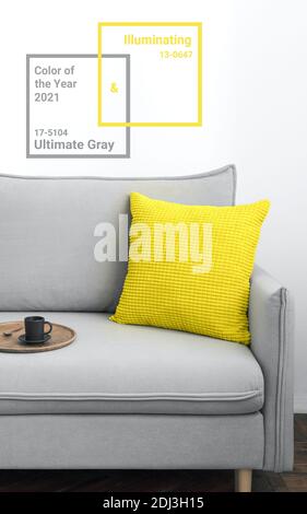 Illuminating yellow and ultimate Gray - trendy colors of year 2021 in interior. Gray sofa with yellow pillow in modern scandinavian style room interior. Vertical crop for social media, copy space Stock Photo