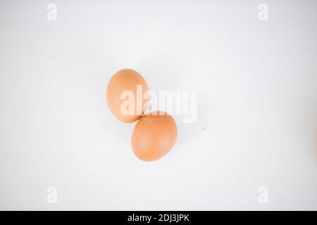 Two eggs isolated on a white table from above Stock Photo