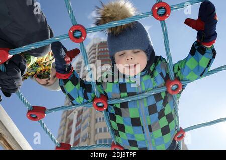 Portrait of boys on climbing net in spring Stock Photo