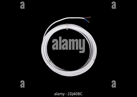 White electricity power cable isolated on black background. Top view on white rolled cable isolated on black Stock Photo