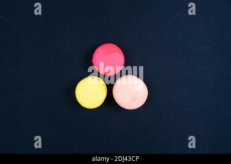 Colourful stack of macaroons isolated on plain black background. Copyspace Stock Photo