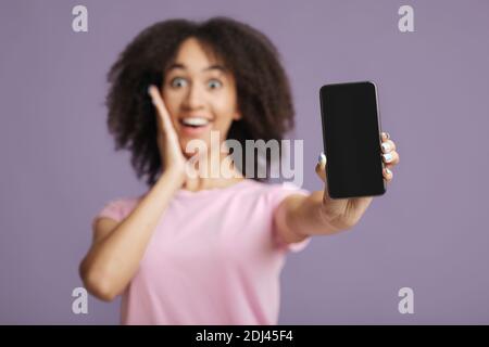 Cashback, online win and amazing message. Surprised african american woman in casual clothes, presses hand to face Stock Photo