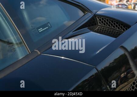 Close up detail of the rear left air intake duct and side window on a metallic black first generation Lamborghini Gallardo V10 sports car Stock Photo