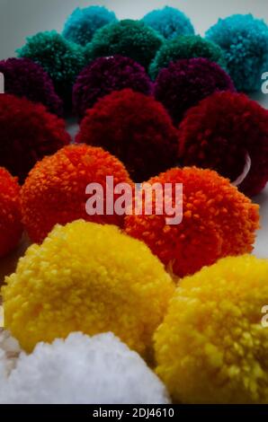 A vertical shot of colorful wool pom poms for fabric decoration Stock Photo