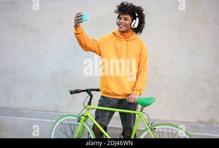 Young millennial african guy making video call on mobile phone outdoors in the city - Focus on face Stock Photo
