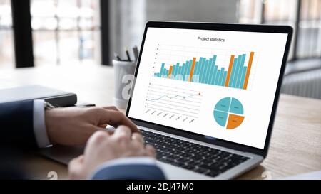 Close up businessman working with project statistics, using laptop Stock Photo