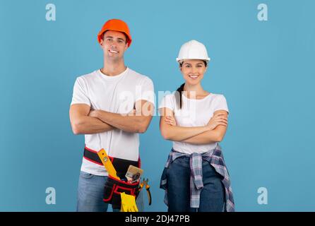 Confident young couple in hard hats ready for house repairment and renovation Stock Photo