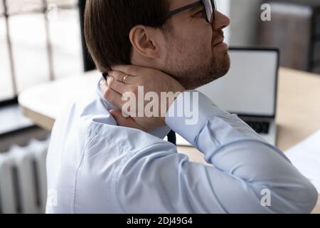 Close up unhealthy businessman suffering from pain in neck Stock Photo