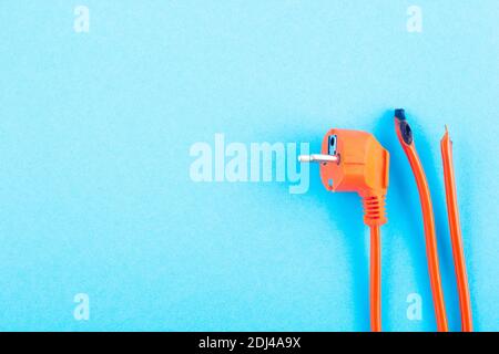 burnt electrical wire on blue background. Copy space Stock Photo