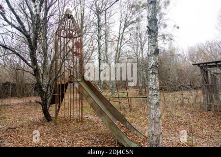 Scary and abandoned playground in a village near Pripyat, a ghost city in the Chernobyl exclusion area. Stock Photo
