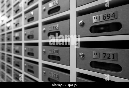Modern mail box of apartment filled home numbers of resident. Mailbox in a row in letter box office of apartment. Post office and envelope mail delive Stock Photo