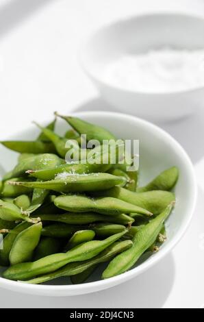 organic edamame beans snack in bowl on table with sea salt Stock Photo