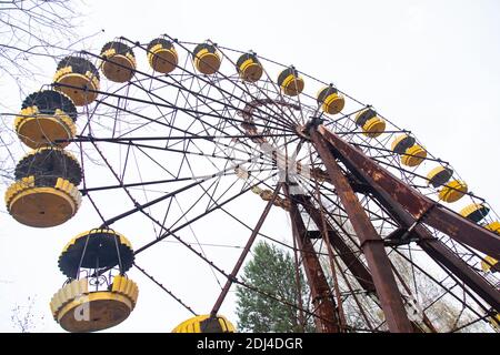 The rusty and famous ferris wheel in the abandoned luna park of Pripyat, a ghost city in the Chernobyl exclusion area. The ferris wheel is a symbol of Stock Photo