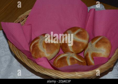 breakfast wicker basket with homemade bread rolls on table Stock Photo