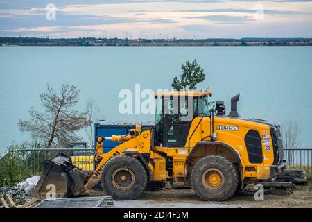 Work on the shore of the Sedlitzer See in Lusatian Lake District. The village of Sedlitz can be seen on the horizon, Germany 2020. Stock Photo