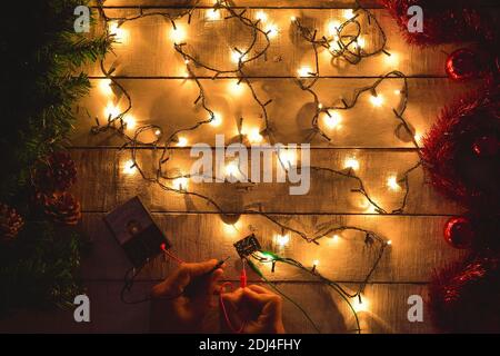 repairing christmas tree lights with decorations on the table Stock Photo