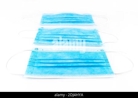 Three blue surgical masks for personal protection against the virus, isolated on a white background. Stock Photo