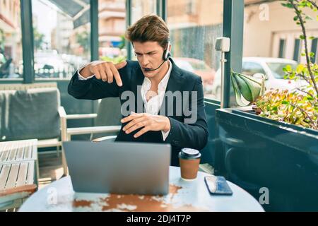 Young caucasian businessman with smiling happy doing video call using laptop at coffee shop terrace. Stock Photo
