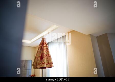 beautiful wedding dress of indian bride hanging from roof Stock Photo