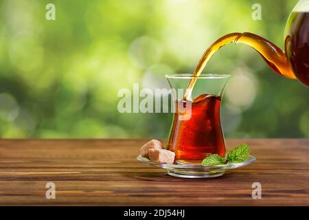 tea pouring from teapot into glass Stock Photo