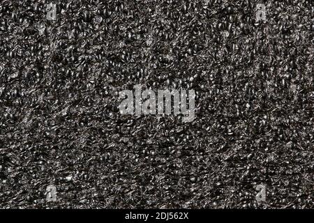 Black Expanded polyethylene foam sample background. EPE beads packing material with macro details, textures and one solid color. Stock Photo