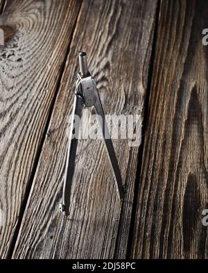 Metal compasses on a wooden table. Stock Photo