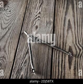 Metal compasses on a wooden table. Stock Photo