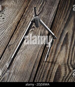 Metal compasses on a wooden table. Stock Photo